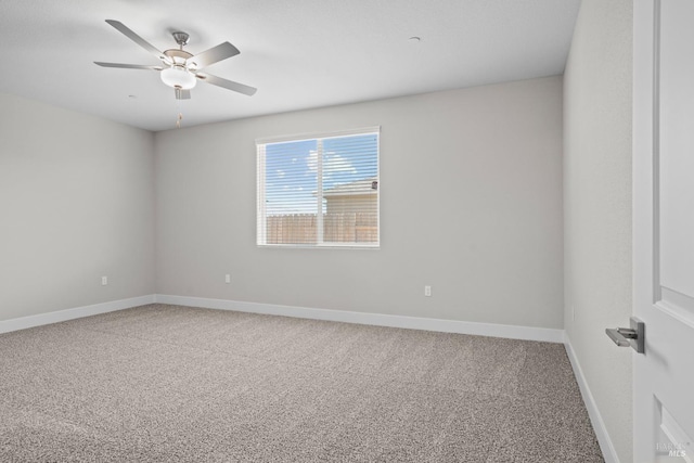 carpeted spare room featuring ceiling fan and baseboards