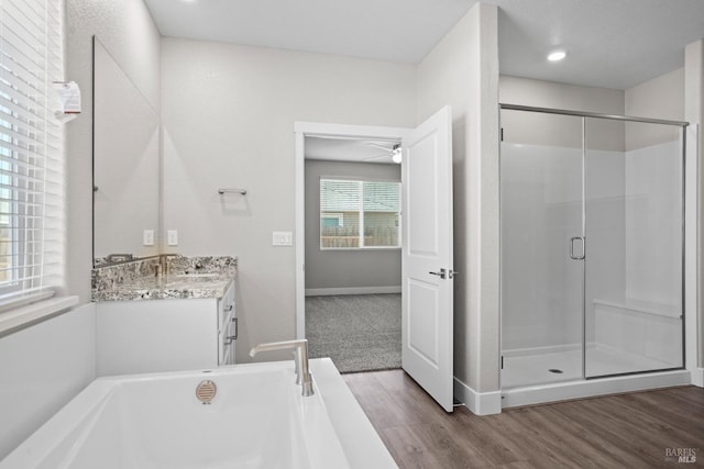 full bathroom with vanity, a shower stall, wood finished floors, and a tub