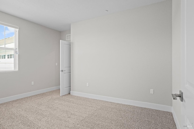 spare room featuring visible vents, baseboards, and light colored carpet