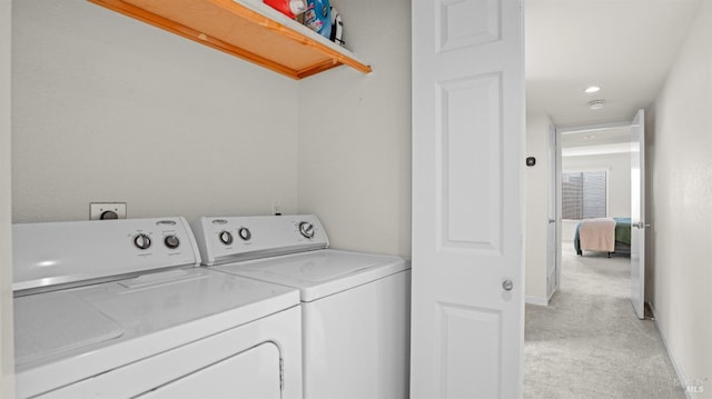 washroom with washer and dryer, laundry area, and light carpet