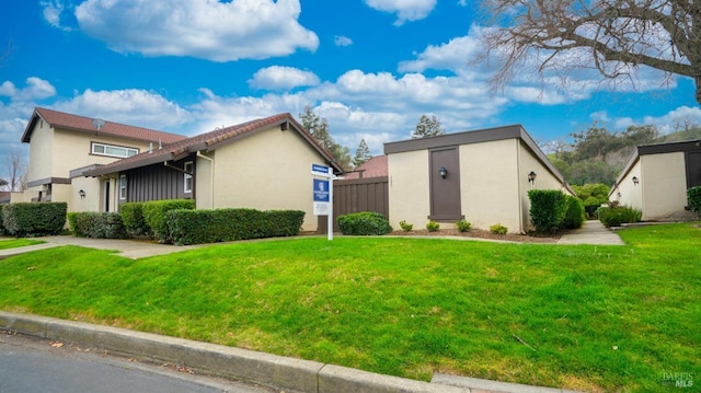 view of side of home with fence, a lawn, and stucco siding