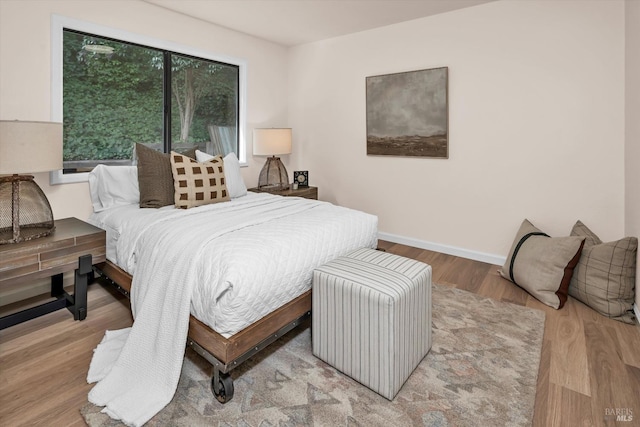 bedroom with light wood finished floors and baseboards