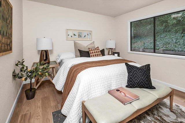 bedroom featuring baseboards and wood finished floors