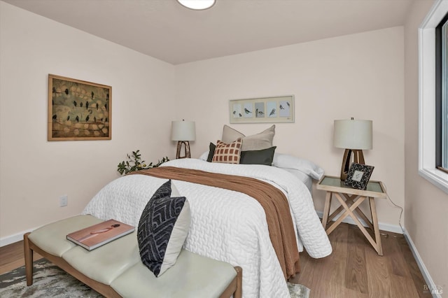bedroom featuring baseboards and wood finished floors