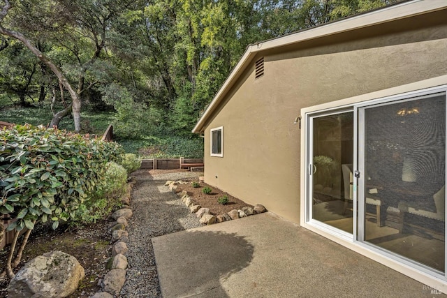 view of side of home featuring a patio area and stucco siding