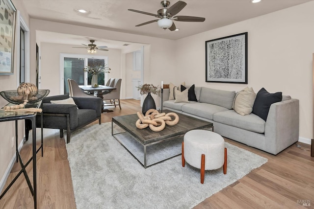 living room with recessed lighting, light wood-style flooring, and baseboards