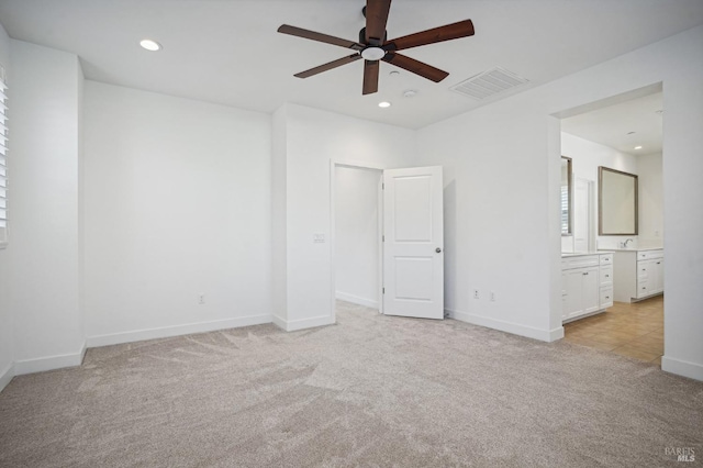 unfurnished bedroom with recessed lighting, light colored carpet, visible vents, connected bathroom, and baseboards