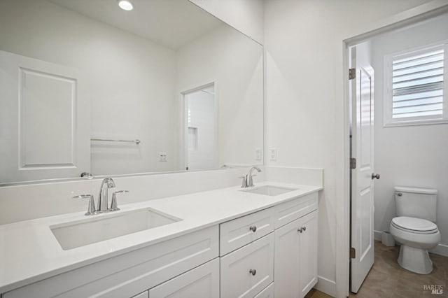 bathroom with tile patterned flooring, a sink, toilet, and double vanity