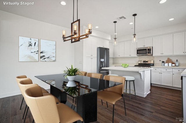 dining space featuring baseboards, dark wood-type flooring, visible vents, and recessed lighting