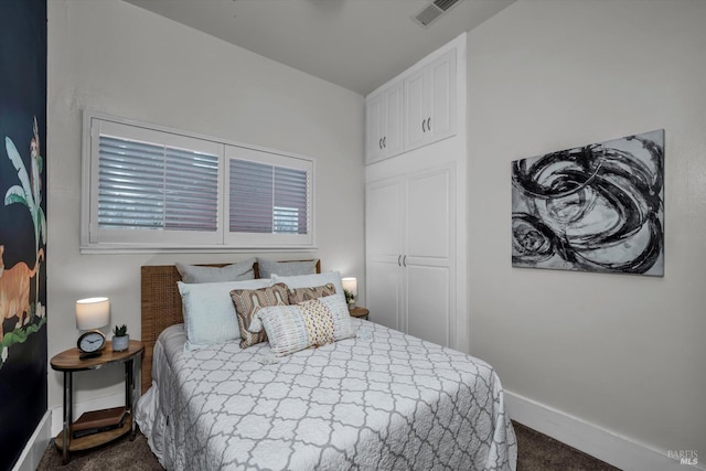 bedroom featuring baseboards, visible vents, and dark colored carpet