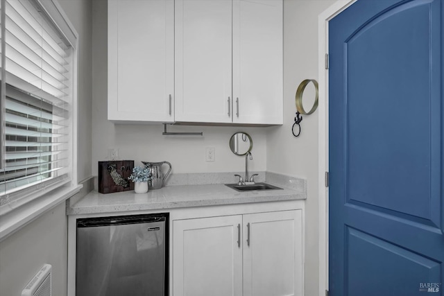 bar featuring freestanding refrigerator and a sink