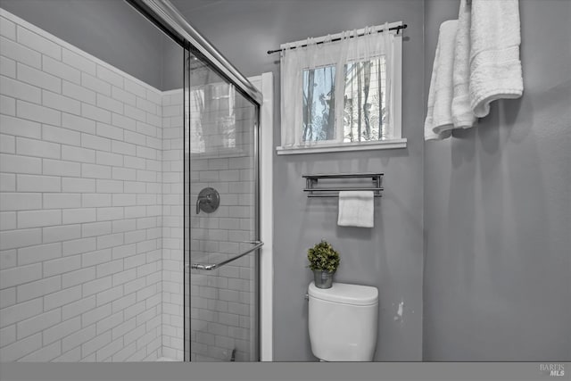 bathroom featuring a shower stall and toilet