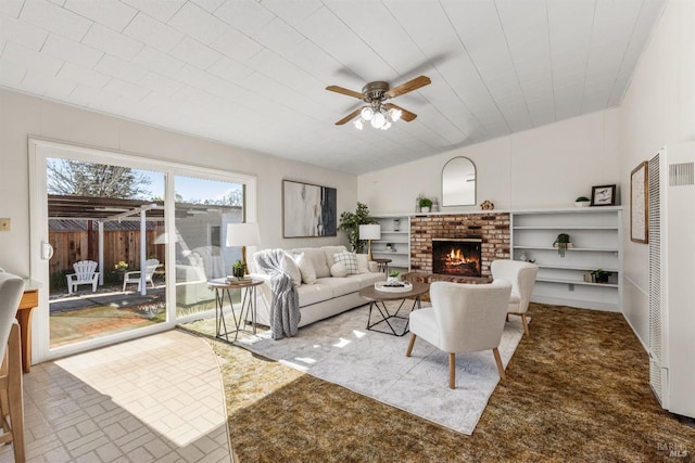 living room with a ceiling fan, a brick fireplace, and brick floor