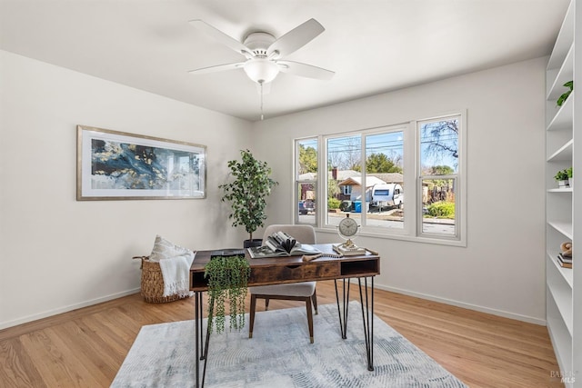 office space featuring light wood finished floors, a ceiling fan, and baseboards