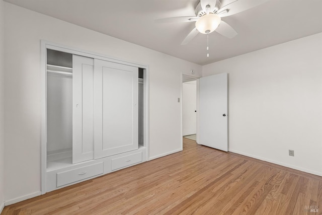 unfurnished bedroom with ceiling fan, a closet, light wood-type flooring, and baseboards