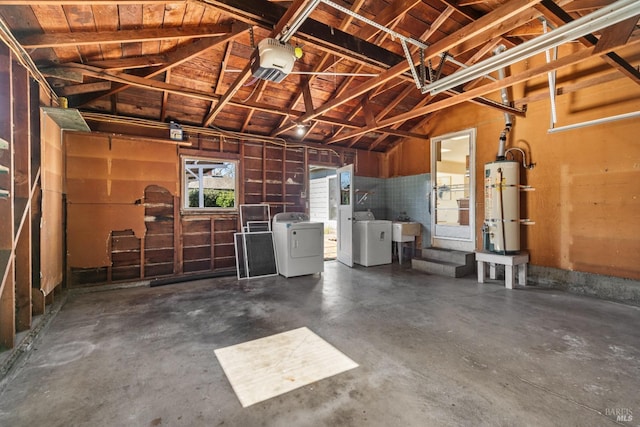 garage featuring a garage door opener, strapped water heater, and washing machine and clothes dryer