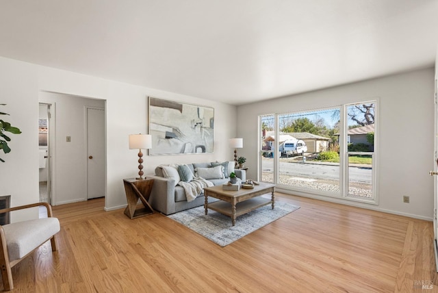 living area with light wood-type flooring and baseboards