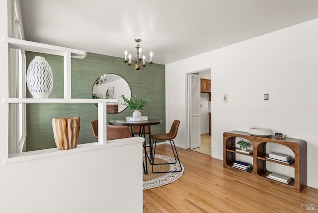 dining room with a notable chandelier, baseboards, and wood finished floors