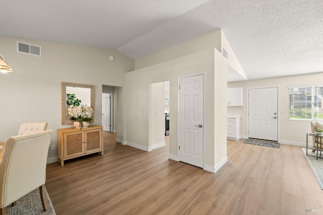 home office with lofted ceiling, visible vents, and light wood-style flooring