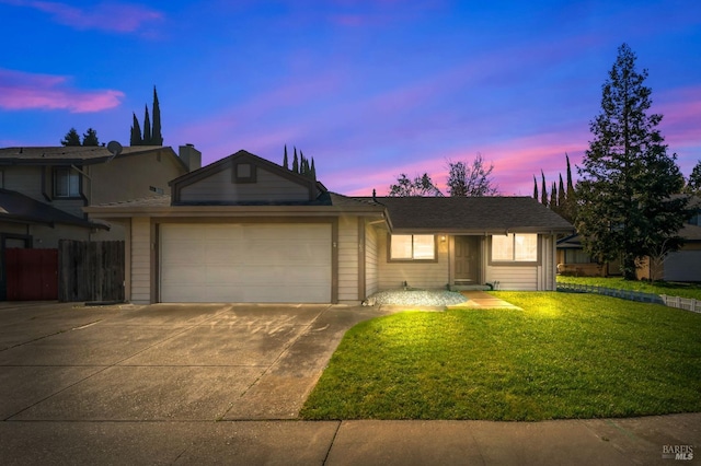 single story home with concrete driveway, a lawn, and an attached garage