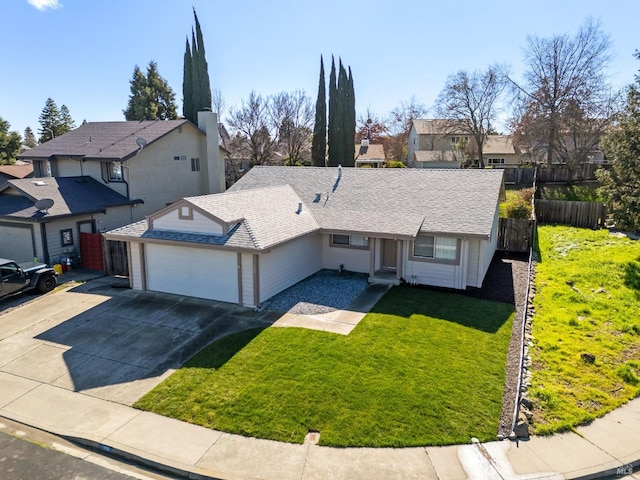 view of front facade featuring an attached garage, concrete driveway, a front yard, and a residential view