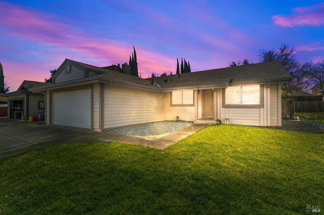 ranch-style house featuring driveway, a yard, and an attached garage