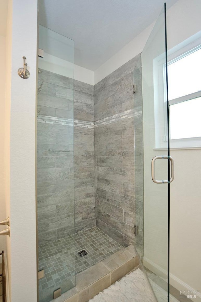 bathroom featuring a stall shower and baseboards