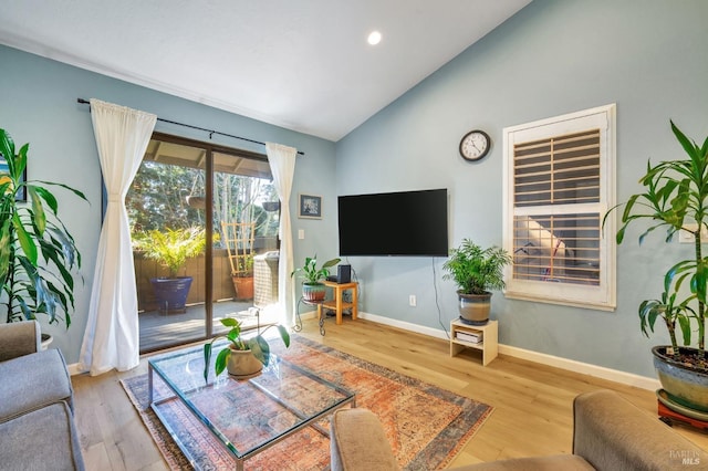 living room featuring vaulted ceiling, baseboards, and wood finished floors