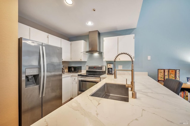 kitchen featuring a sink, white cabinetry, appliances with stainless steel finishes, wall chimney range hood, and light stone countertops