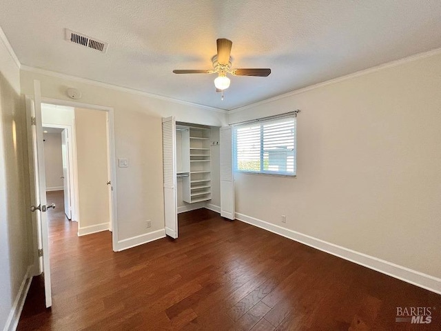 unfurnished bedroom with dark wood-type flooring, visible vents, and ornamental molding