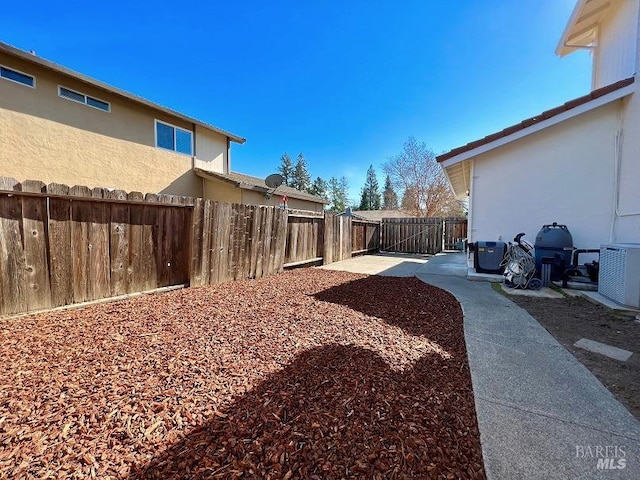 view of yard with cooling unit, a fenced backyard, and a patio