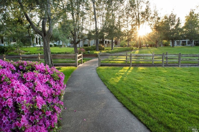 view of property's community with a yard and fence