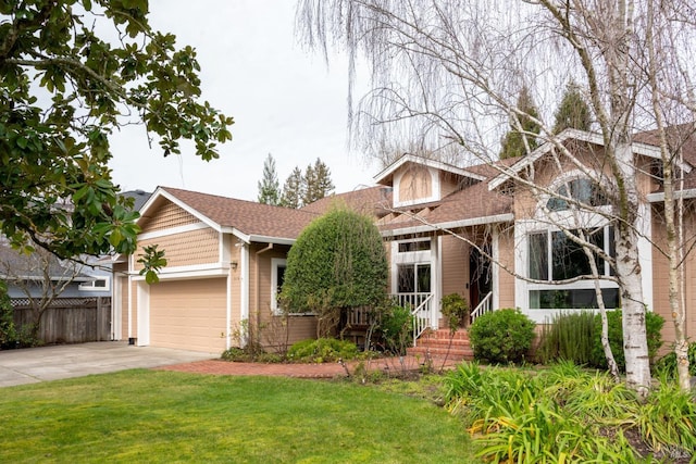 view of front facade with an attached garage, fence, a front lawn, and concrete driveway