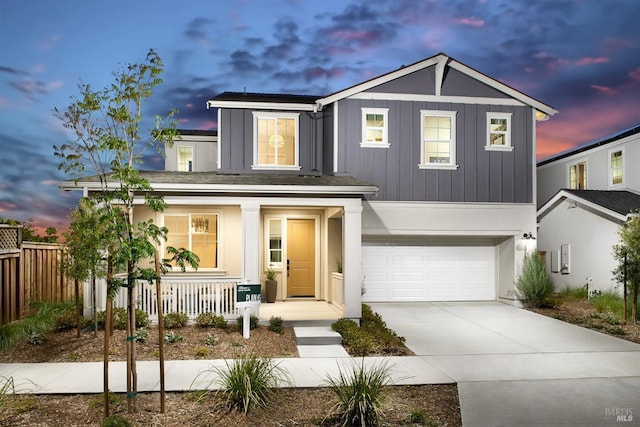 traditional home with driveway, a garage, covered porch, fence, and board and batten siding