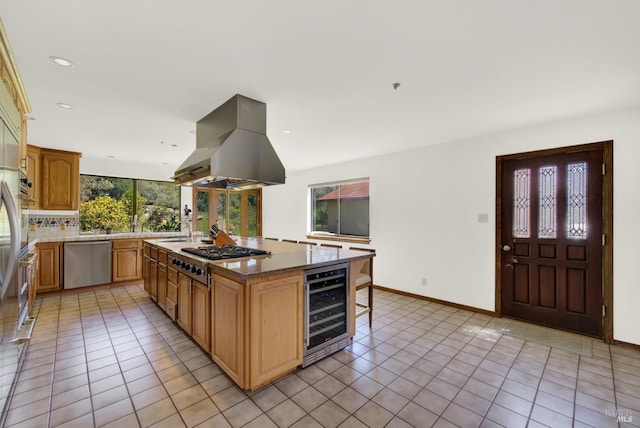 kitchen featuring light tile patterned flooring, beverage cooler, appliances with stainless steel finishes, decorative backsplash, and island exhaust hood