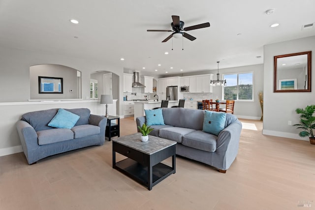 living room with recessed lighting, visible vents, light wood-style flooring, a ceiling fan, and baseboards