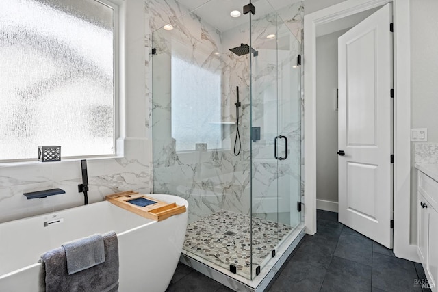 full bathroom featuring a soaking tub, a marble finish shower, tile walls, and tile patterned floors