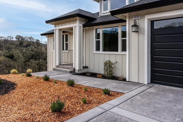 property entrance featuring roof with shingles and board and batten siding