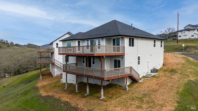 rear view of house with a deck, a yard, and central air condition unit