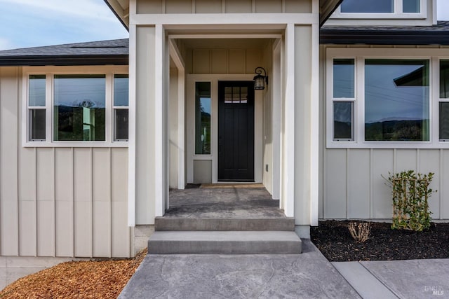 entrance to property featuring board and batten siding and a shingled roof