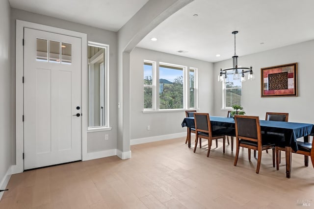 dining area featuring visible vents, baseboards, arched walkways, light wood-style flooring, and recessed lighting