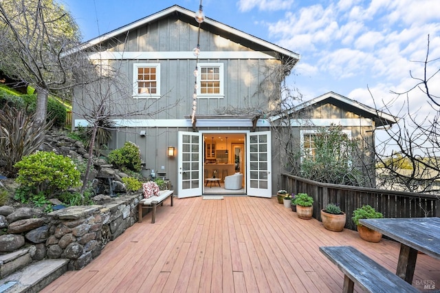 rear view of house featuring board and batten siding and a wooden deck