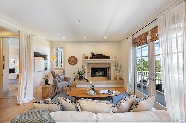 living area featuring a high end fireplace, crown molding, recessed lighting, and wood finished floors