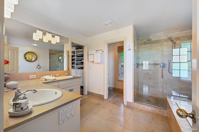 full bathroom with tile patterned flooring, vanity, baseboards, a spacious closet, and a stall shower