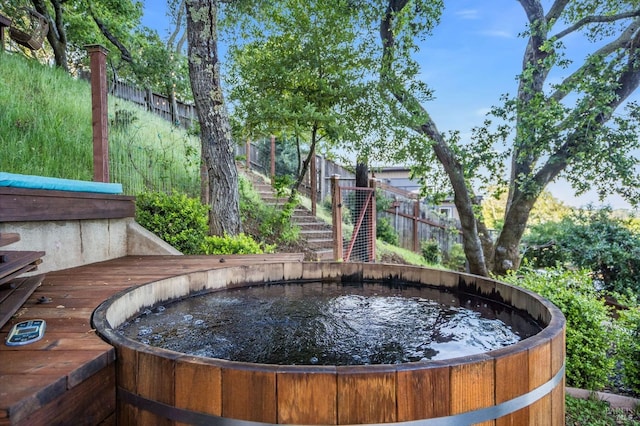 exterior details with stairway, fence, and a hot tub