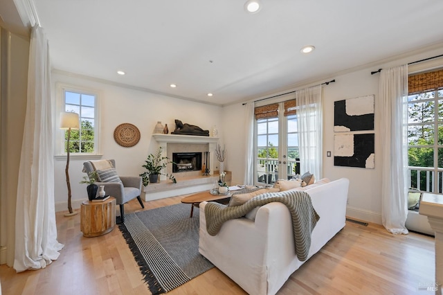 living area with light wood-style floors, visible vents, and a healthy amount of sunlight