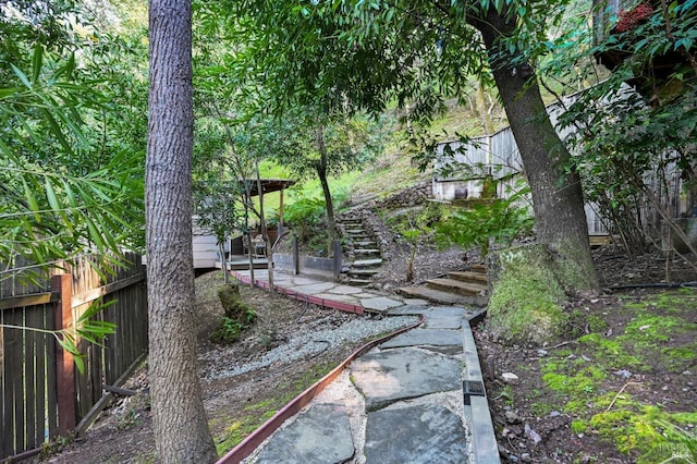 view of yard featuring fence and stairway