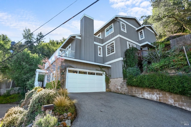 view of front of property with a garage, a balcony, and driveway