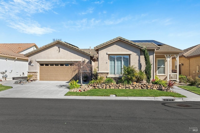 view of front facade with a garage, driveway, solar panels, stone siding, and stucco siding