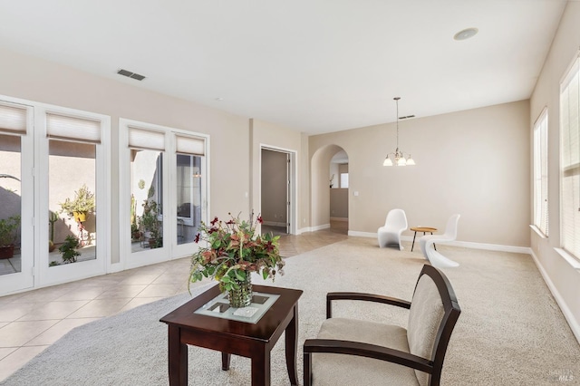 living area with arched walkways, visible vents, and plenty of natural light